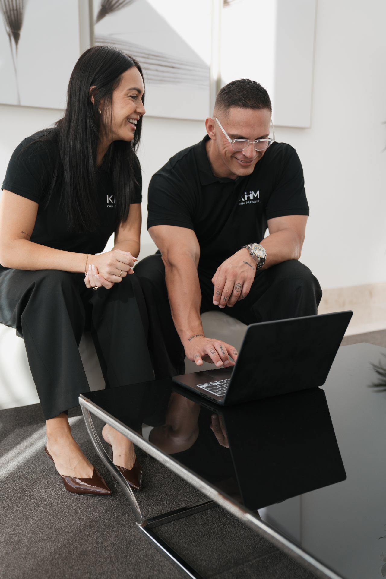 Watene Waenga and Erin Fale seated together reviewing work on a laptop